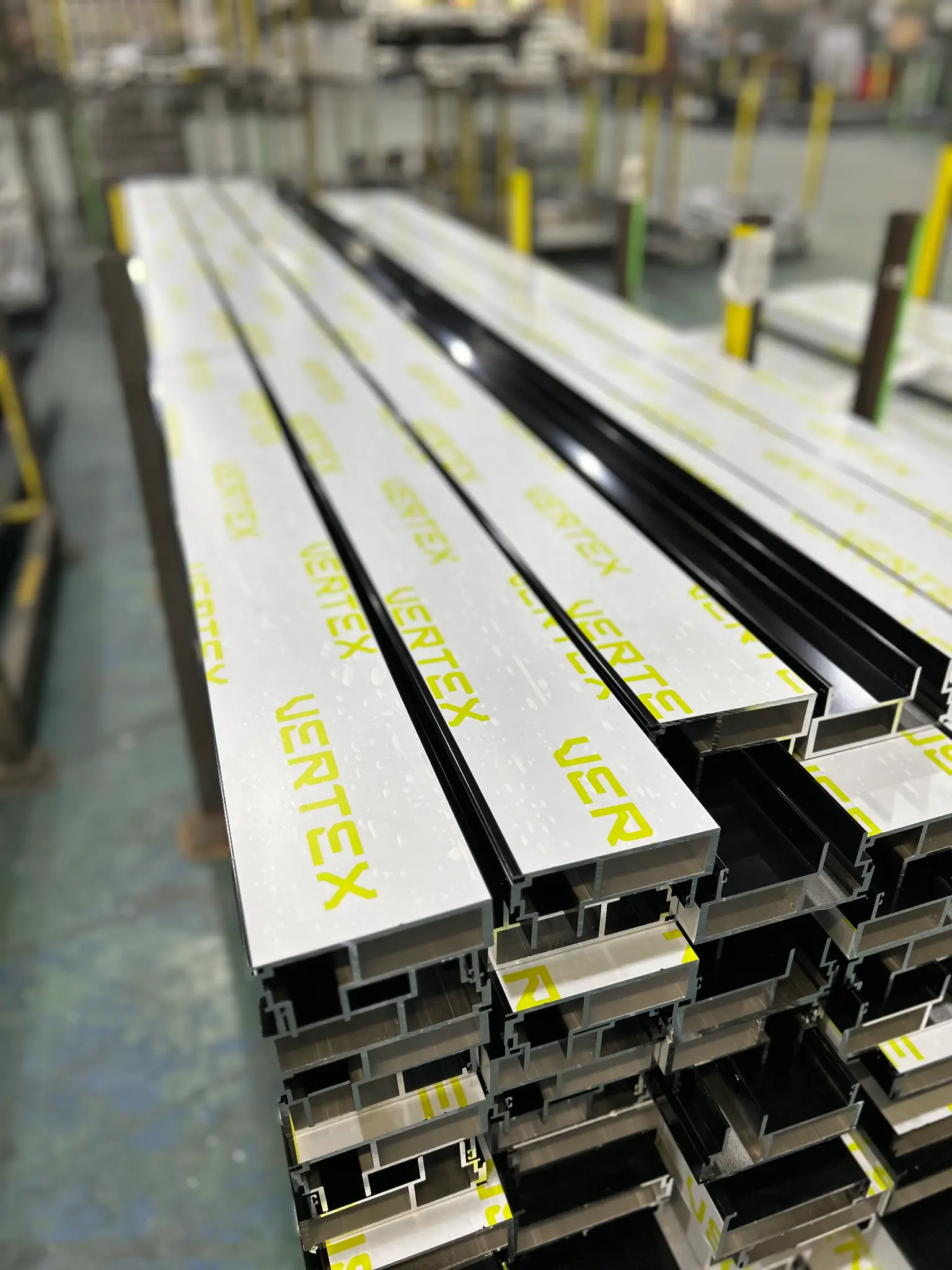 Vertex Facades branded aluminium extrusions stacked in the fabrication facility, ready for dispatch