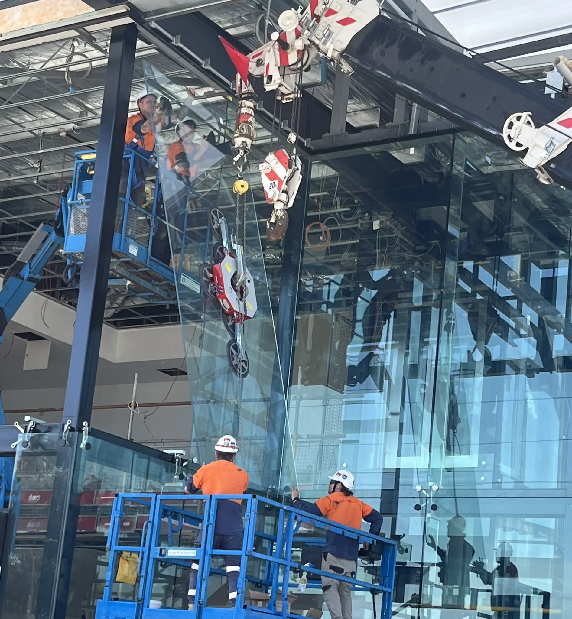 Vertex Facades crew using a vacuum lifter to install a large structural glass panel on a commercial project in Perth WA